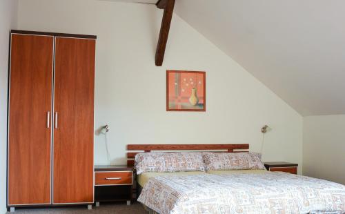 1 dormitorio con 1 cama y armario de madera en Pension U Milana, en Dvůr Králové nad Labem