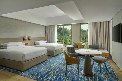 a hotel room with two beds and a table at Petaling Jaya Marriott Hotel in Petaling Jaya