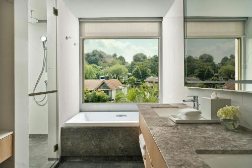 a bathroom with a tub and a large window at Petaling Jaya Marriott Hotel in Petaling Jaya