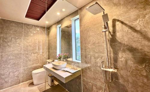 a bathroom with a sink and a glass shower at PALM Minh Chau Hotel-Only for Vietnamese in Quang Ninh