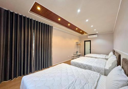 a bedroom with two beds and a window at PALM Minh Chau Hotel-Only for Vietnamese in Quang Ninh