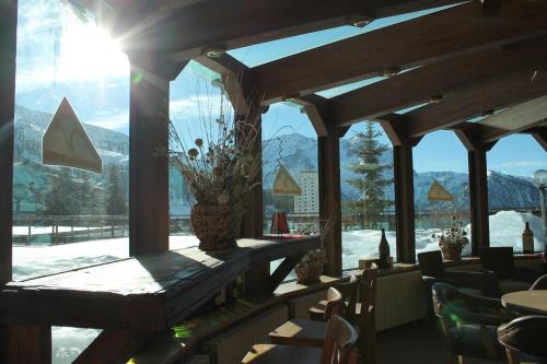 a restaurant with a view of the mountains through the windows at Grand Hotel Sestriere in Sestriere