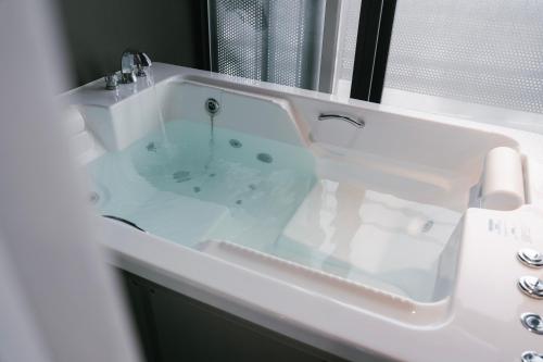 a white bath tub with a sink in a bathroom at Hotel Parangvue in Goseong