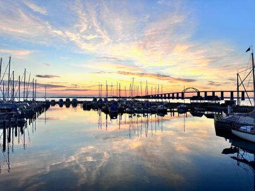 a marina with boats in the water at sunset at Private Apartment Skudehaven in Rudkøbing