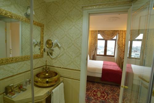 a bathroom with a bed and a sink and a mirror at Galatower Hotel in Istanbul