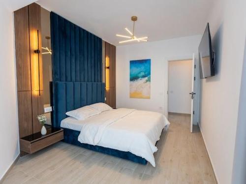 a bedroom with a large bed with a blue wall at Apartament Lara mamaia in Mamaia Sat/Năvodari