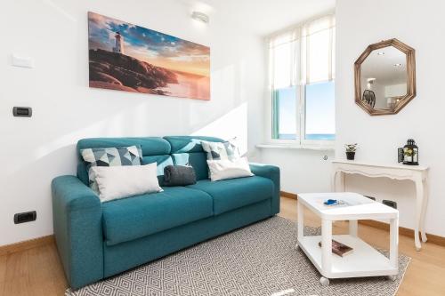 a living room with a blue couch and a mirror at -Fronte Mare- Centro Storico in Varazze