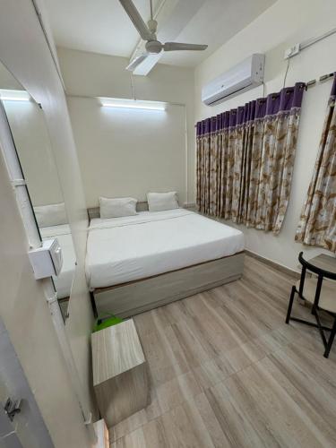 a small bedroom with a bed and a table at Ghate rooms in Nagpur