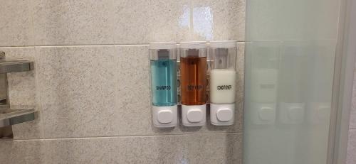 a row of different colored glass bottles on a wall at Casa Leonardo in Tirano