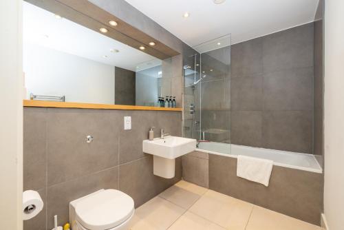 a bathroom with a toilet and a sink and a shower at Cosy, modern high rise with views! 2 bedroom in London