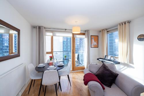 a living room with a couch and a table at Cosy, modern high rise with views! 2 bedroom in London