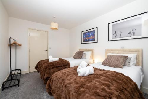 a bedroom with two beds with white towels on them at Cosy, modern high rise with views! 2 bedroom in London