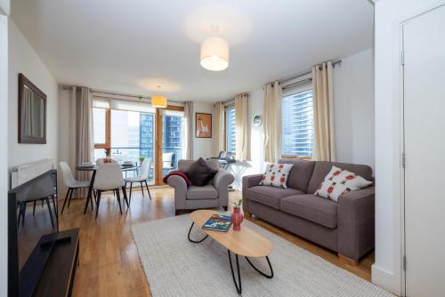 a living room with a couch and a table at Cosy, modern high rise with views! 2 bedroom in London