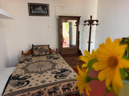 a bedroom with a bed and a mirror and flowers at Beliya Rock View in Dambulla