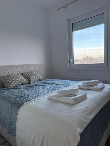 a bedroom with a bed with two towels on it at Panonski Mornar in Palić