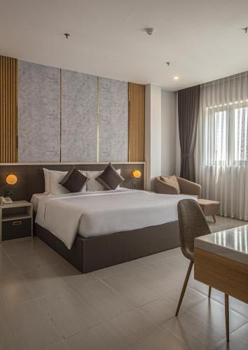 a bedroom with a large bed and a couch at Dan Thanh Hotel in Can Tho