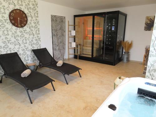 a living room with two chairs and a bath tub at Le Foyer Celtique in Ploërmel
