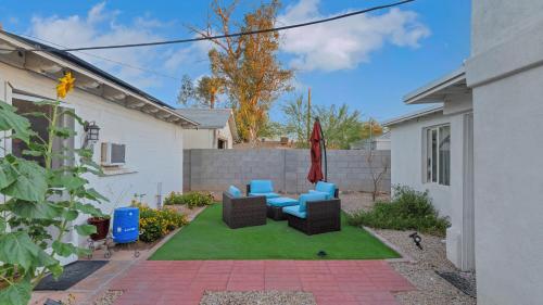 a backyard with a patio with chairs and an umbrella at ULTRA COZY CASITA BY DTWN PHX in Phoenix