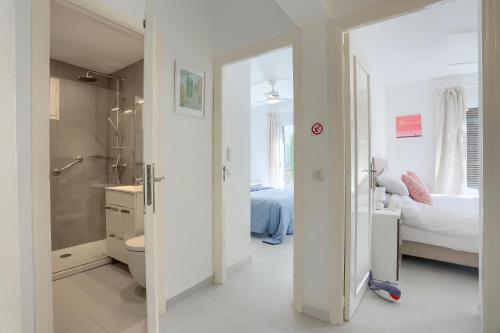 a white bathroom with a toilet and a bedroom at Cordonyer in Port de Pollensa