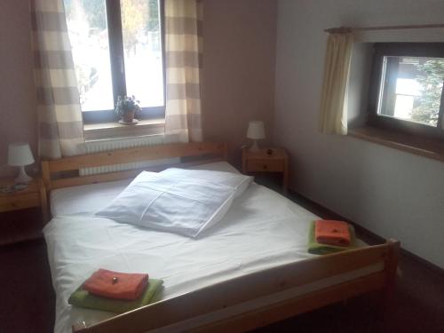 a bedroom with a bed with two towels on it at Hotel Anna in Harrachov