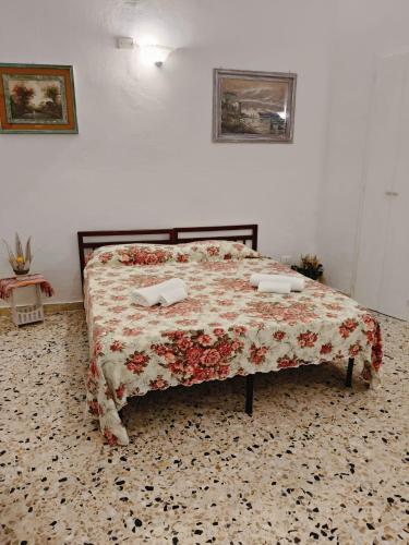 a bedroom with a bed with a floral bedspread at Antica dimora LUNA in Casarano