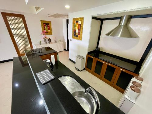 a kitchen with a sink and a counter top at Kata Seaview Escape - 1BR Luxury Apartment 90sqm in Phuket