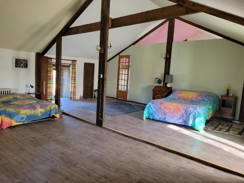 a bedroom with two beds in a room at Ferme fruitière zéro traitement in Ernée