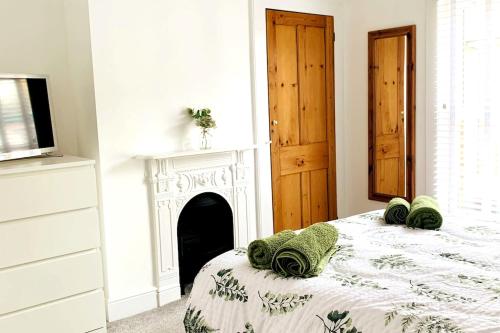 a white bedroom with a bed and a fireplace at Number 15 in Whitstable