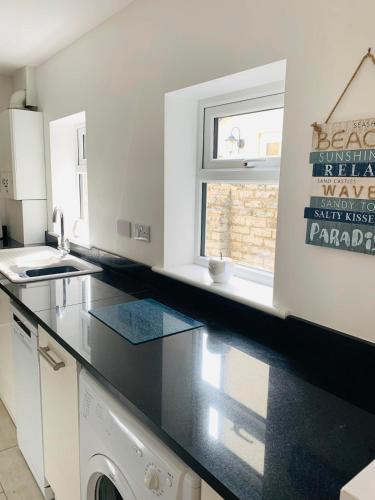 a kitchen with a black counter top and a window at Number 15 in Whitstable