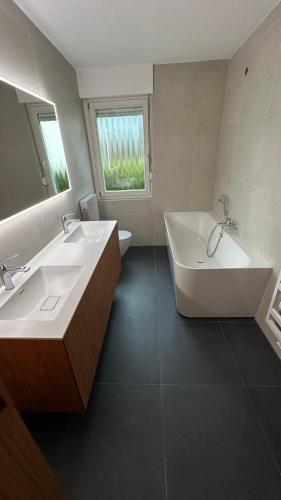 a bathroom with two sinks and a bathtub and a tub and a mirror at Ani's Pearl in Bled