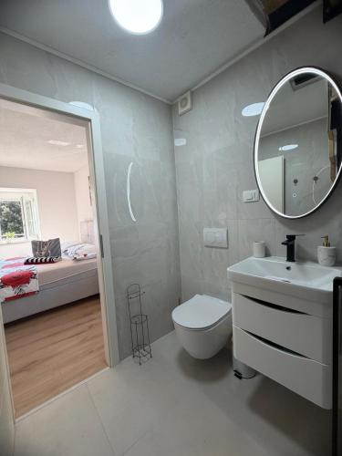 a bathroom with a toilet and a sink and a mirror at LUXURY Rooms Punat in Punat