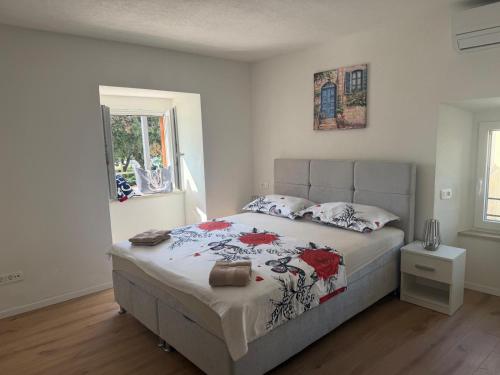 a bedroom with a large bed with red flowers on it at LUXURY Rooms Punat in Punat