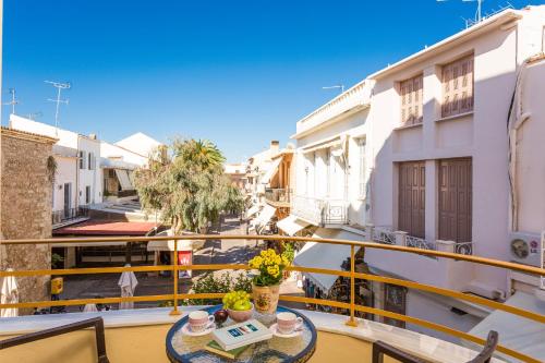 uma varanda com uma mesa e vista para uma rua em Polyxenia Suites em Rethymno Town