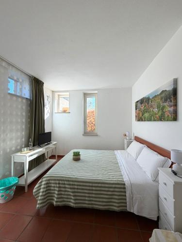a bedroom with a bed and a desk and a television at Bio&B Acquaviva in Otranto