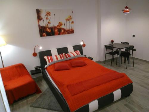 sypialnia z łóżkiem z pomarańczowym kocem i stołem w obiekcie Apartament Salezego w Warszawie