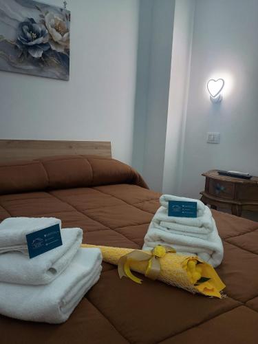 a bed with towels and a stuffed animal on it at LETIZIA'S HOME Caserta in Caserta
