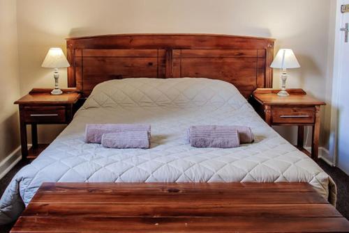 a bedroom with a large bed with two night stands at Colesberg Lodge in Colesberg