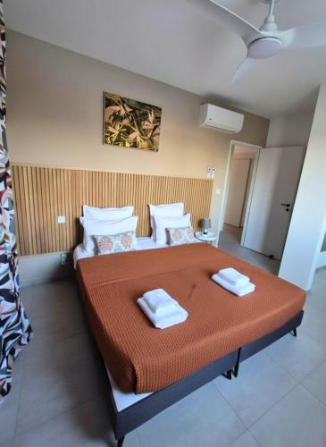 a bedroom with a large bed with two towels on it at Villa Gommier - 3 chambres, 3 sdb, piscine in Le Diamant