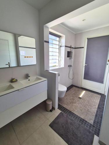 a bathroom with a sink and a toilet and a mirror at Villa Gommier - 3 chambres, 3 sdb, piscine in Le Diamant