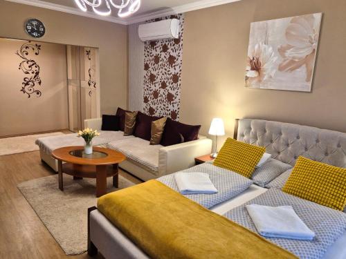 a living room with two beds and a couch at Jókai Apartman Szarvas in Szarvas