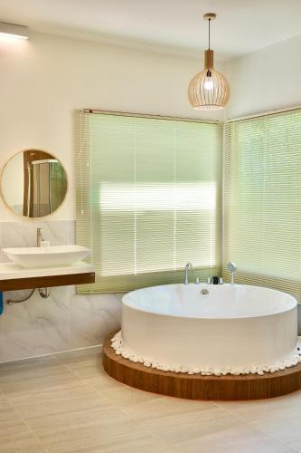 a bathroom with a large tub and a sink at Yugen House - Yutaka in Nong Prue