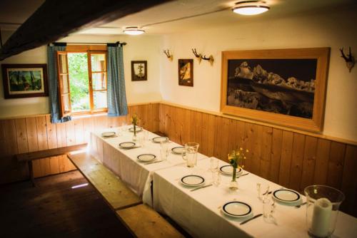 a group of tables in a room with a painting at Leislinghütte in Bad Goisern