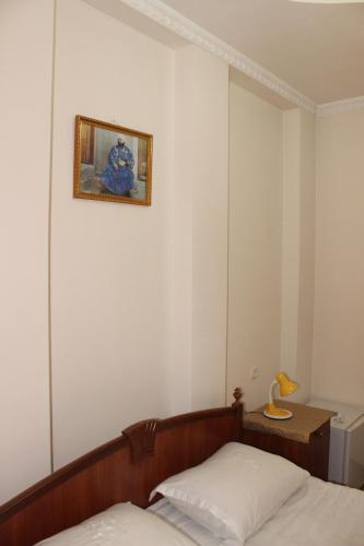 a bedroom with a bed and a picture on the wall at Hotel Nazira & Azizbek in Bukhara