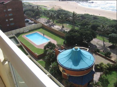 a view of a building with a swimming pool and the beach at Stella Maris Apartment 132 in Amanzimtoti