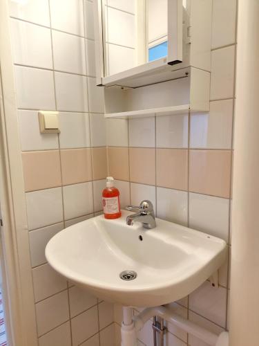 a bathroom with a white sink and a mirror at Sun life room in Stockholm