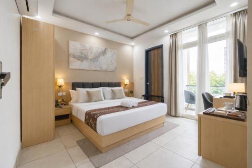 a hotel room with a bed and a television at Fortune Inn Sector - 104 By ASPL in Noida