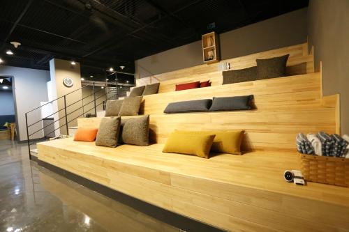 a large wooden bench with many pillows on it at With U Hotel & Guesthouse in Sokcho