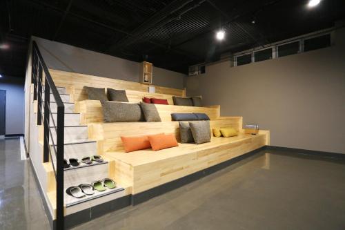 a wooden bed with pillows on it in a room at With U Hotel & Guesthouse in Sokcho