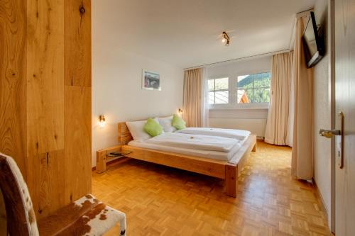 a bedroom with a bed and a large window at Bacchus Saas-Fee in Saas-Fee