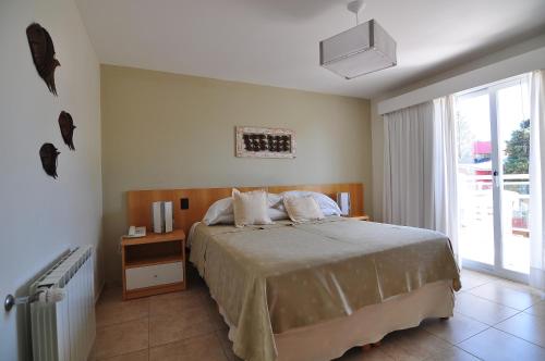 Un dormitorio con una cama grande y una ventana. en Hosteria Chaltu, en Villa Gesell